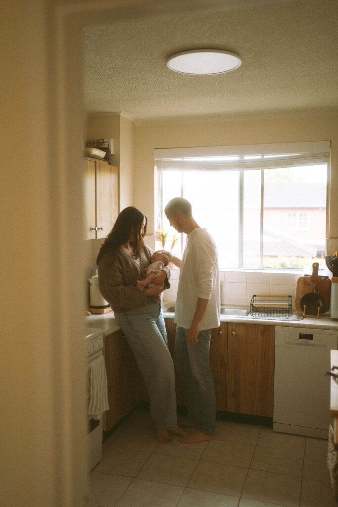 Parents holding baby Maisie in a vintage inspired kitchen