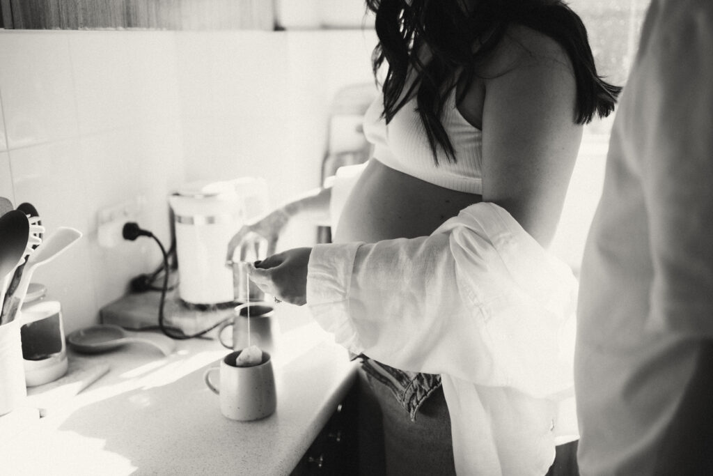 Expectant couple having tea during an in-home maternity photoshoot