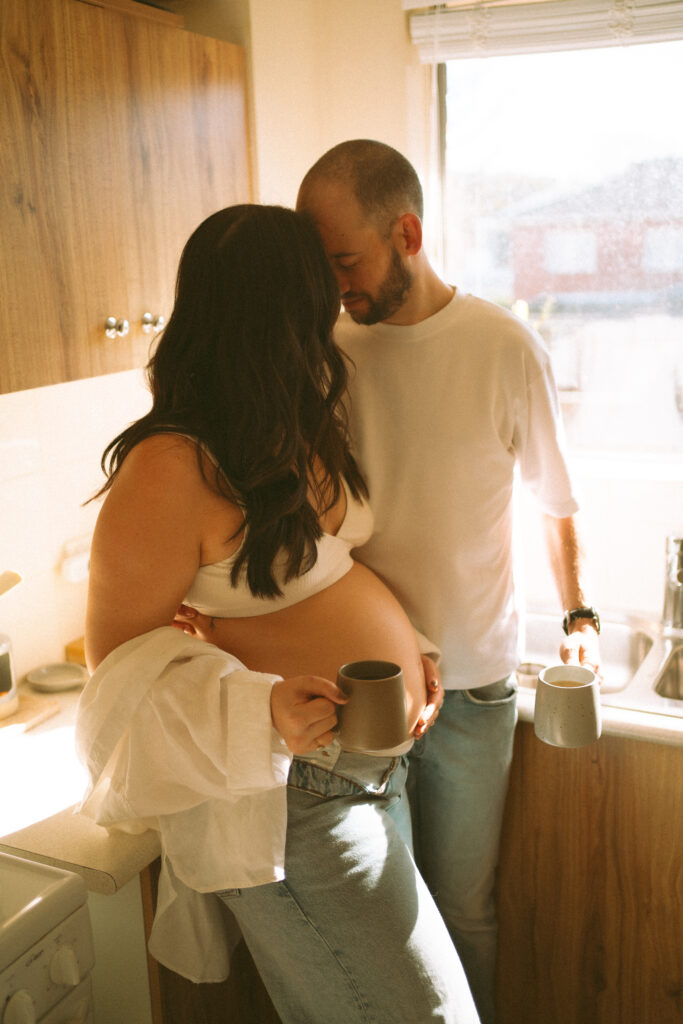 Expectant couple having tea during an in-home maternity photoshoot