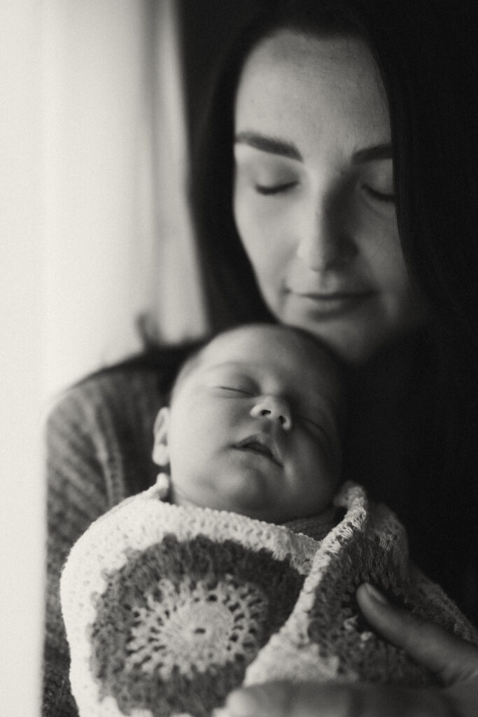 Mother and baby wrapped in a blanket.