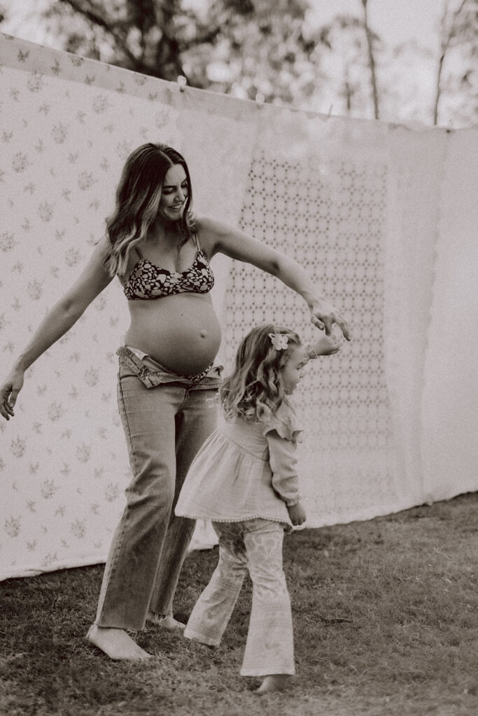 Mother dancing with a toddler during a By Joey Motherhood Mini session.