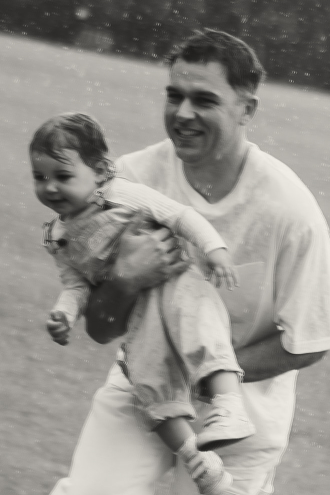 a father dancing in the ran with his daughter